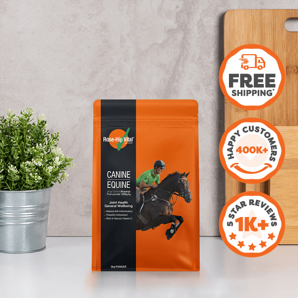 Rose-Hip Vital refill bag with horse and rider graphic, potted plant, and wooden board on gray surface